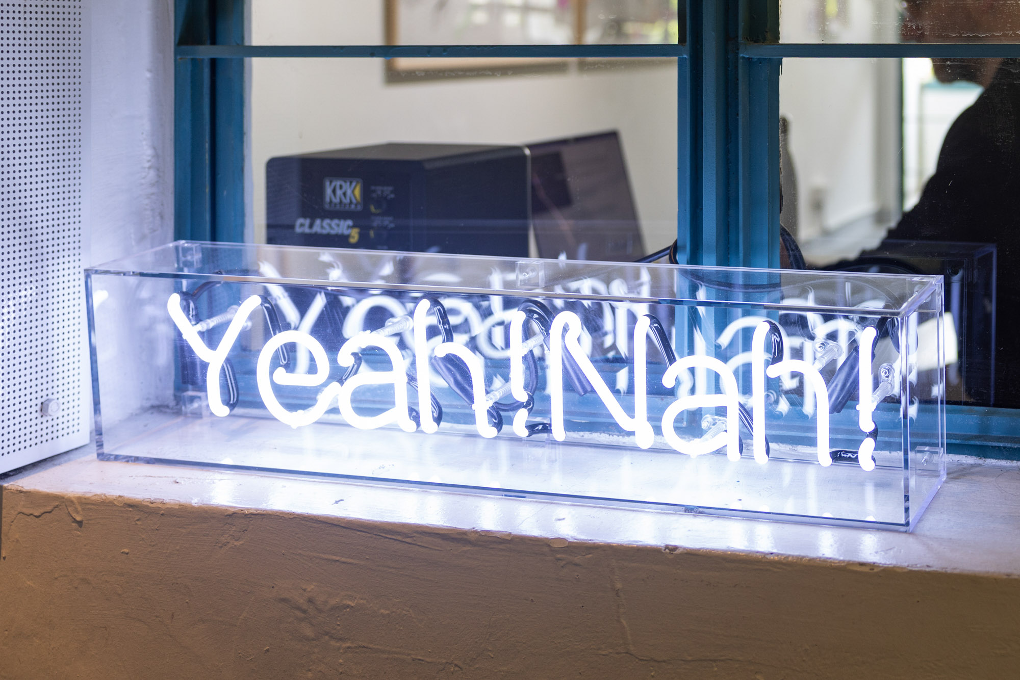 Photograph of a neon light with the text Yeah!Nah!